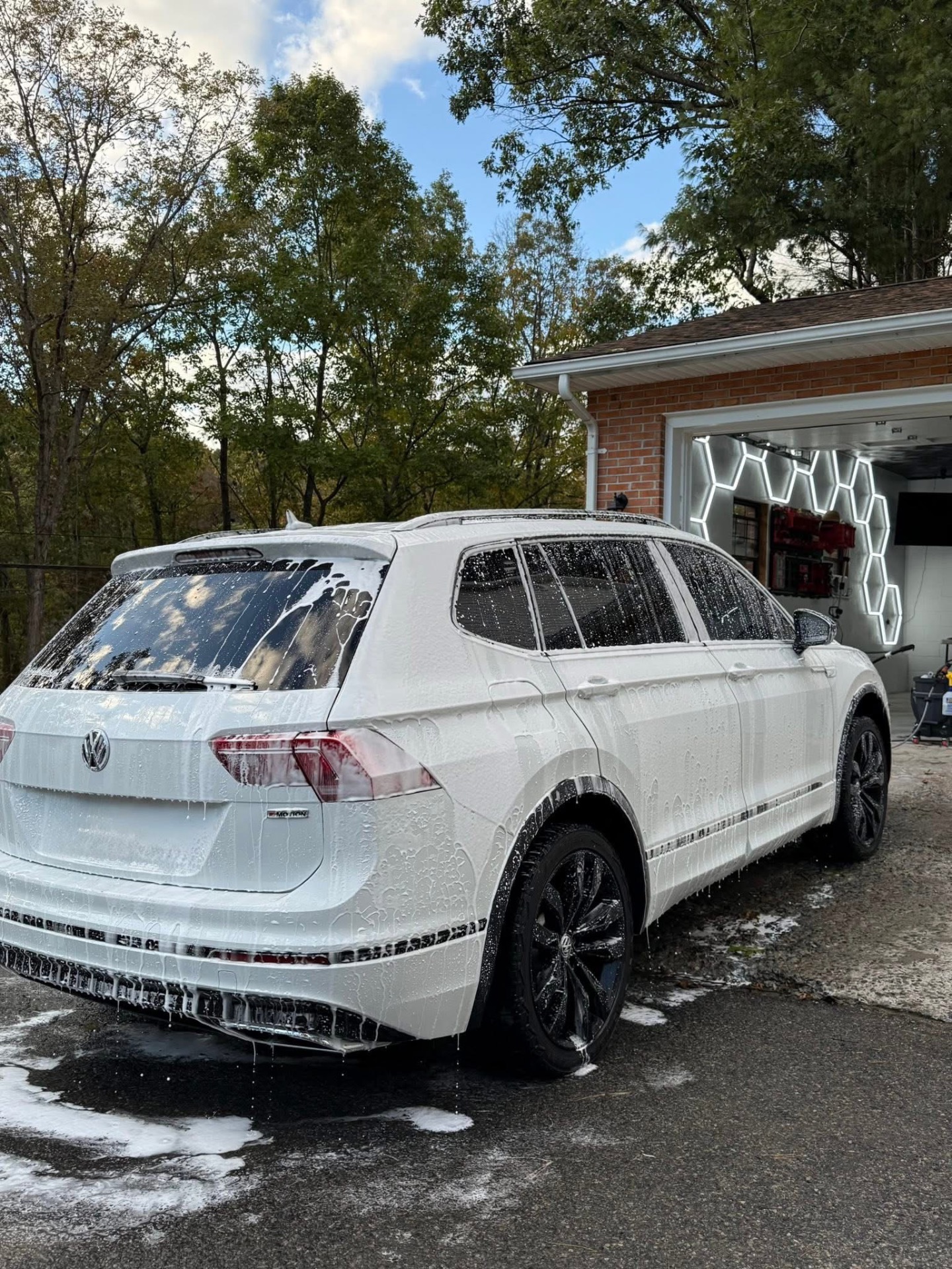 White Volkswagen Tiguan covered in wash foam in the driveway