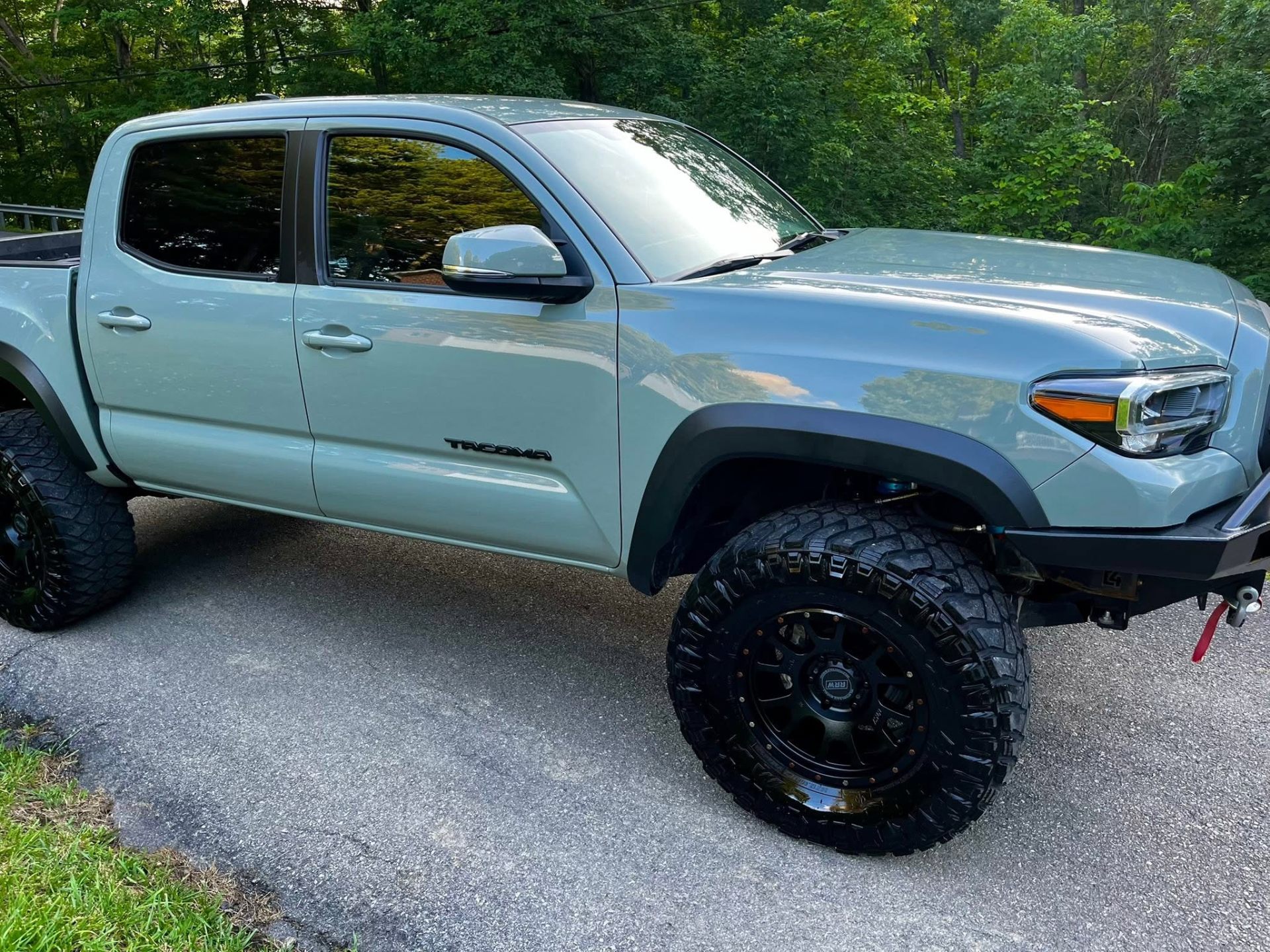 Lifted grey Toyota Tacoma with a clean glossy finish