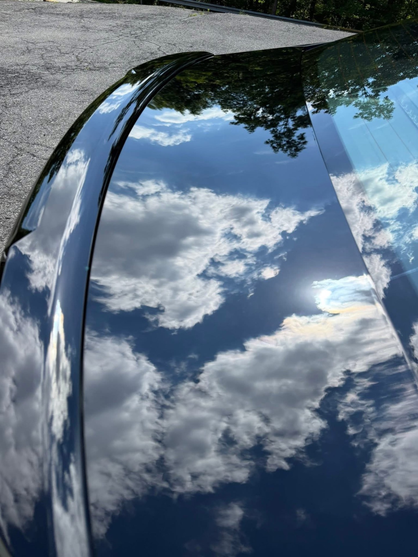 Deep gloss black paint reflecting the sky after detailing