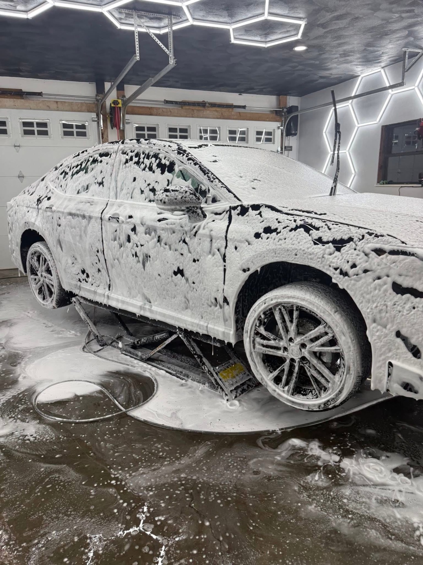 Toyota Camry covered in thick snow foam on the wash pad
